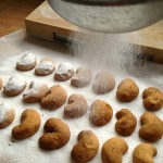 sieving icing sugar onto the kourabiedes